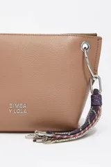 Bolso bandolera de estructura rígida y tamaño mediano confeccionado en piel vacuna. Presenta asa regulable, cierre con cremallera, bolsillo interior y logo metálico de la marca. Incluye un charm decorativo con borlas en el lateral y acabados metálicos.