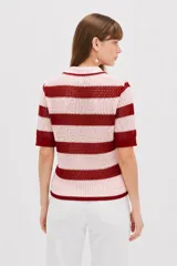 Top de punto calado con rayas horizontales en color rosado y rojo, de manga corta, con cuello tipo polo y cierre frontal con botones.