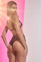 Conjunto de bikini negro de lycra brillante, corpiño triangular embolsado con breteles anchos fijos y bombacha tiro medio.