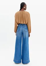 Pantalón de jean azul de corte palazzo con costuras verticales en el frente.