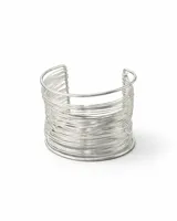 Pulsera tipo brazalete ancho y rígido, compuesta por múltiples alambres delgados plateados enrollados, con una abertura frontal.