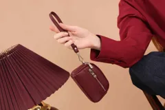 Monedero de dama con correa de mano, confeccionado en material símil cuero con textura granulada. Cuenta con doble compartimento principal con cierre y un bolsillo frontal con cierre, ideal para organizar tarjetas, billetes y monedas.