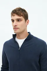 Campera tejida azul marino con cuello elevado, cierre frontal completo, logo bordado en el pecho y corte regular.