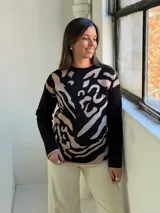 Sweater de tejido de punto con diseño estampado abstracto en tonos negro y beige, de cuello redondo y manga larga.