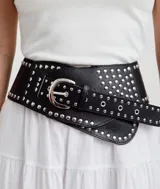 Cinturón ancho de cuero sintético negro con hebilla metálica plateada y apliques de tachas metálicas plateadas.