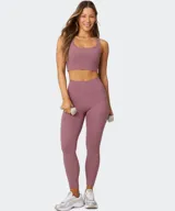 Calza deportiva Fabletics modelo PureLuxe Oasis de tiro alto y largo 7/8, en color malva, con bolsillos laterales de fácil acceso.