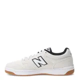 Championes urbanos New Balance modelo 480, de diseño inspirado en el skate, color blanco con detalles en negro y suela de goma color caramelo.