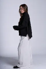 Sweater tejido de punto color blanco, con cuello alto tipo media polera, mangas largas y dobladillo asimétrico con aberturas laterales.