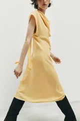 Vestido midi de corte evasé confeccionado en mezcla de modal, con cuello fluido tipo drapeado, manga sisa caída y abertura en la espalda.