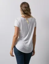 Blusa blanca de modal con cuello redondo y escote en V. Tiene apliques de crochet en el escote y los hombros.