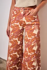 Jean wide leg de tiro medio, con estampado botánico en tonos terracota y beige, confeccionado en denim de algodón con elastano.