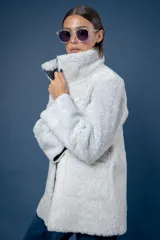 Campera reversible de cuero ovino, color azul marino, con interior de piel sintética blanca. Presenta cuello alto, cierre frontal y bolsillos frontales aplicados.