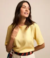 Blusa de viscolino color amarillo pálido, con cuello redondo y mangas cortas abullonadas.