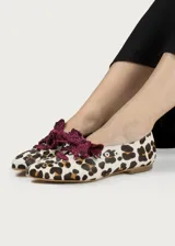 Bailarina de cuero con estampado animal print, decorada con tachuelas plateadas y un lazo desmontable de tela metalizada en color fucsia.