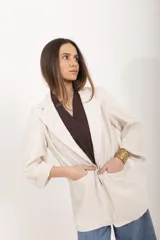 Blazer color beige de corte recto y calce relajado, con cuello de solapas, bolsillos delanteros aplicados y mangas con vuelta. Confeccionado en lino y viscosa con forro de batista.