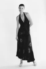 Vestido largo de Zara Woman Collection confeccionado en tejido satinado negro con estampado floral a contraste. Presenta cuello halter ajustable con lazada en la espalda y corte fluido.