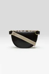 Bandolera de diseño media luna confeccionada en cuero con pelo natural y estampado animal print de leopardo. Cuenta con cierre superior de cremallera, correa de algodón ajustable y herrajes metálicos.