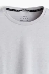 Remera deportiva de manga larga con cuello redondo, confeccionada en tejido funcional transpirable con tecnología DryMove que absorbe el sudor. Presenta un diseño liso con aberturas laterales en el bajo y corte estándar.
