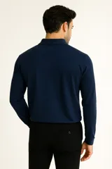 Remera de manga larga color negro, confeccionada en algodón, con cuello tipo polo y tapeta de tres botones.