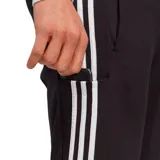 Pantalón de jogging Adidas Essentials Single Jersey negro con tres rayas blancas a los costados y logo de la marca bordado en blanco.