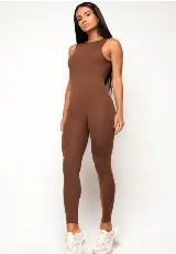 Mono deportivo largo de una pieza, color marrón, con cuello redondo alto y diseño sin mangas. Confeccionado en tejido de poliamida con efecto modelador y ajuste de compresión media.