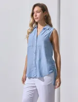 Camisa sin mangas color beige, marca Zac & Rachel, confeccionada en lino. Presenta escote en V, abertura frontal con botones, dos bolsillos delanteros y terminación con botones en los laterales.