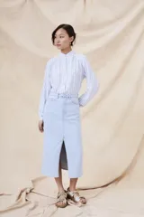 Camisa de manga larga con cuello mao y estampado a rayas verticales celestes y blancas.