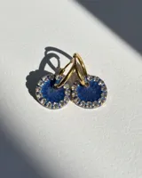 Aros de acero quirúrgico con dije circular de resina rosa y borde de strass dorados.