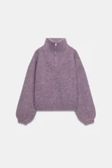 Jersey de punto con cuello alto y cierre frontal de cremallera metálica, de manga larga con puños ajustados y diseño holgado.