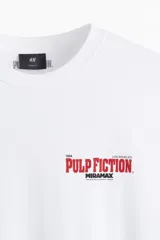 Remera de algodón de corte holgado con cuello redondo y mangas cortas con hombros caídos. Presenta un estampado pequeño en el pecho con el logo de la película Pulp Fiction.