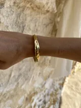 Esclava rígida de diseño artesanal con textura irregular y acabado metálico, ideal para uso diario.