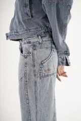 Pantalón de jean color marrón con costuras decorativas verticales en el frente, corte recto y tiro medio.