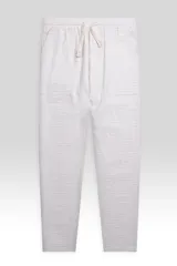 Pantalón color crema confeccionado en tejido ligero de algodón con textura tipo waffle. Presenta cintura elastizada con cordón de algodón ajustable, bolsillos laterales y bolsillo trasero.