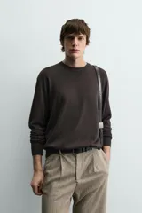 Jersey color crudo de tejido de punto, con cuello redondo y mangas largas. Corte amplio y terminaciones en rib.