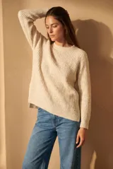 Sweater de punto con textura acanalada, cuello redondo y mangas largas. Presenta un diseño de calce holgado con ruedo redondeado y aberturas laterales.