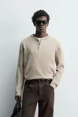 Jersey relaxed fit de punto en hilatura con mezcla de algodón y cashmere. Presenta cuello redondo con cierre frontal de botonadura y manga larga.