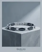 Pulsera de eslabones de acero con piezas centrales en color negro, diseño moderno y elegante.