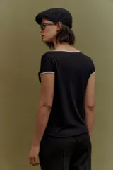 Blusa negra de tejido de punto, con escote en V y mangas cortas con ribete en color crema.