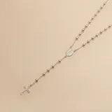 Rosario de plata 925 compuesto por una cadena de eslabones con cuentas esféricas, una medalla central con imagen religiosa y una cruz colgante en el extremo.