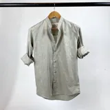 Camisa de algodón color verde claro, con cuello mao y mangas largas con puños abotonados.