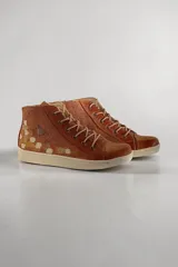 Botas de media caña de cuero color terra con brillo jaspeado en tono cobre, con detalles de arte pintado a mano en el talón, suela de goma blanca y cordones beige.