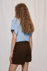 Short cruzado de tiro medio con diseño frontal tipo falda, color negro, de líneas simples y calce cómodo.