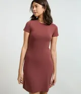 Vestido corto color ladrillo, confeccionado en tejido de punto rib de algodón y elastano. Tiene cuello redondo y mangas cortas.