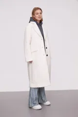 Tapado largo color marfil de poliéster con solapas, cierre con botones y corte holgado.