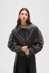 Campera de estilo utilitario en color gris oscuro con efecto lavado, confeccionada en poliéster. Presenta cuello camisero, cierre frontal con cremallera, bolsillos frontales con solapa y puños elásticos.