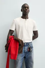 Camiseta blanca de manga corta con cuello redondo y tapeta de botones frontal (cuello panadero o henley).