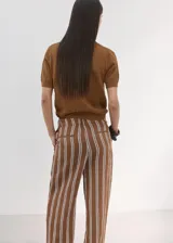 Chaleco de punto fino de algodón con diseño calado, cuello polo, manga corta y cierre frontal con tres botones.