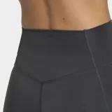 Calza corta deportiva Adidas de tiro alto, con corte ajustado y cintura elástica. Presenta el logo de la marca en la parte frontal y tecnología de tejido transpirable.