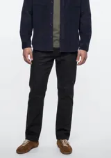 Pantalón de sarga de corte ajustado, color negro, con diseño clásico de cinco bolsillos y trabillas para cinturón.