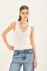 Musculosa de punto compacto color negro, con escote pronunciado y calce al cuerpo.